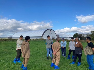 （株）宇野牧場の牧草地を確認する会員